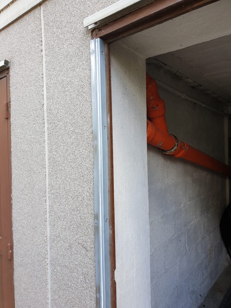 Renfort d'huisserie par cornière métallique, création des points de fermeture sur cette dernière.